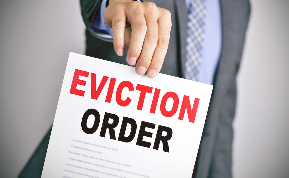 A legal professional holding an eviction document for Headley Legal Support Services.