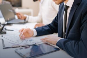Business professionals in formal attire documents at a desk, with laptops and a tablet - Headley Legal Support Services Florida
