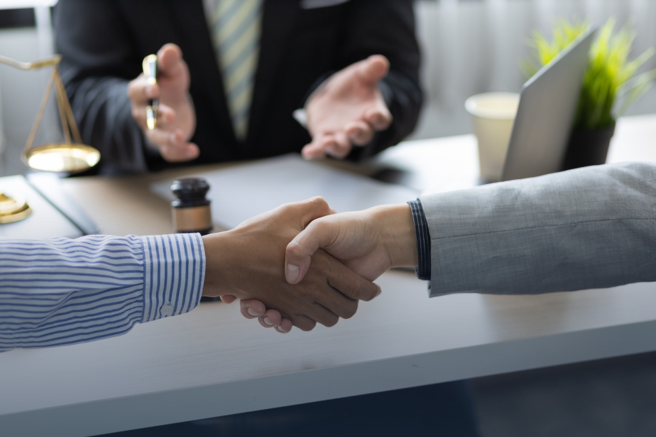 Lawyer and client shaking hands after a legal consultation.