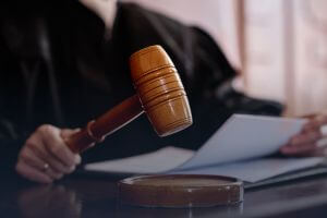 Close-up of judge with gavel and legal documents.