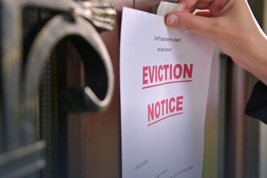 A person holds a notice on paper, displaying important information, with a neutral background.