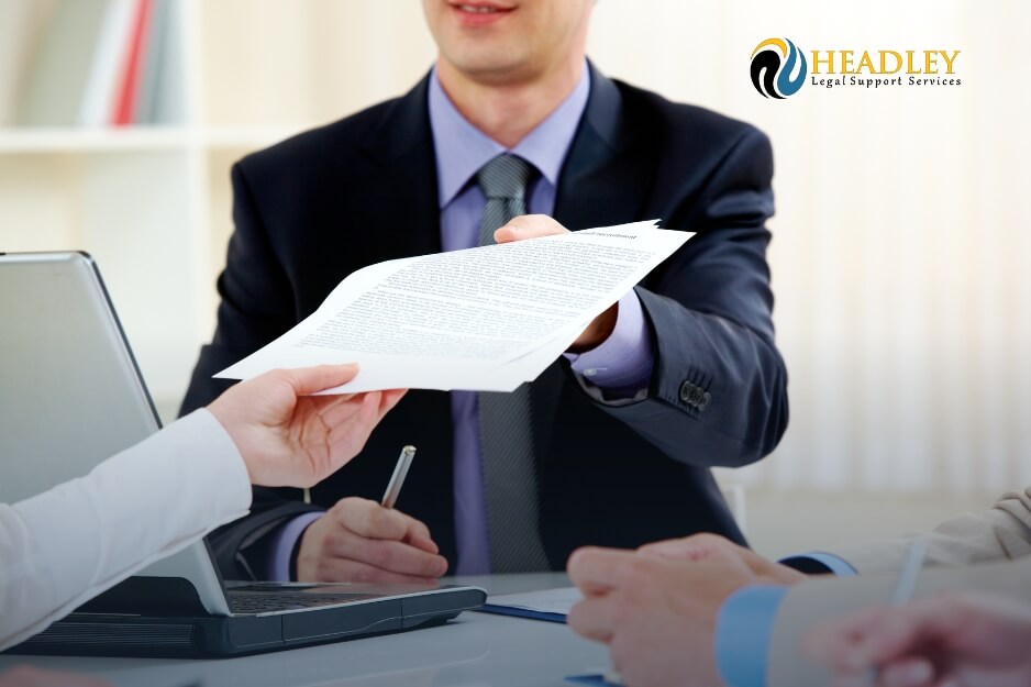 A professional-looking person in business or casual business attire handling a legal document.